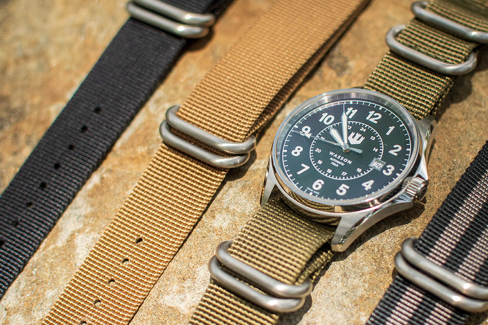 Four zulu straps are laid over a rock.
